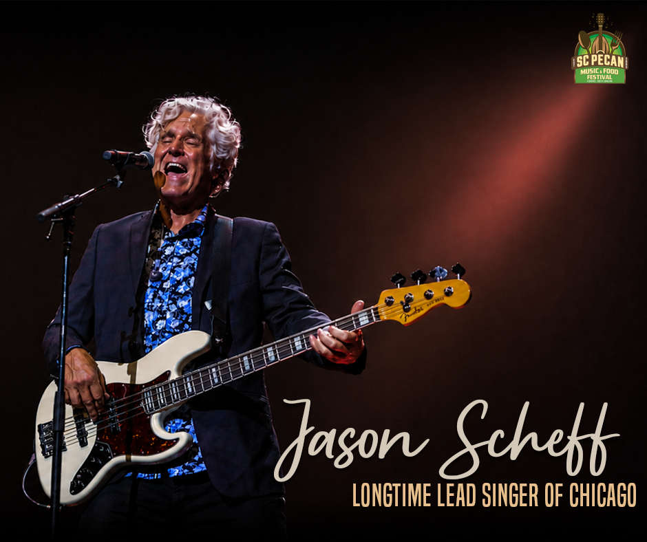 Jason Scheff, longtime lead singer of Chicago plays bass and sings wearing a blue shirt.