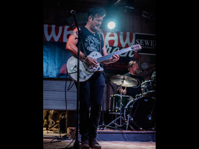Jared Petteys and the Headliners, man performing with a silver glitter guitar.