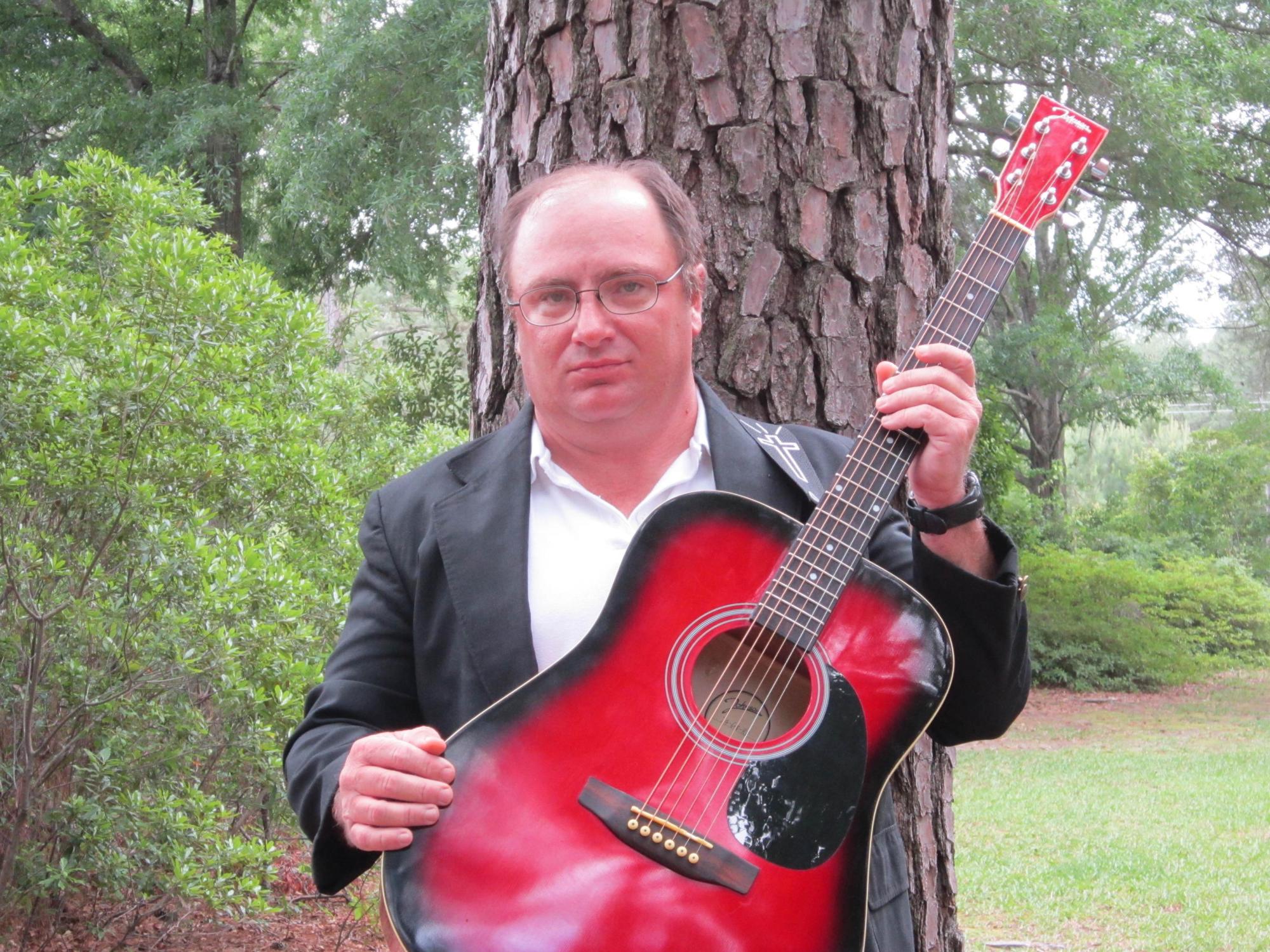 A man holding a red guitar