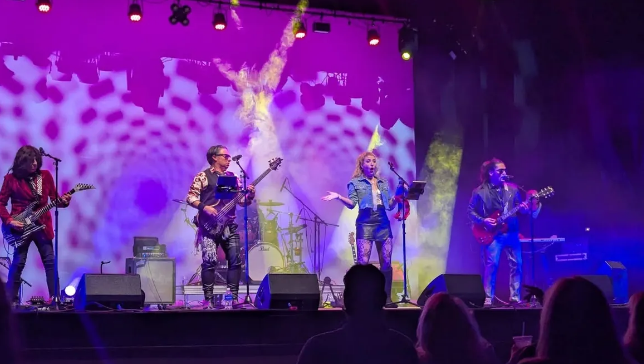 A band with five members plays 80s music on stage.