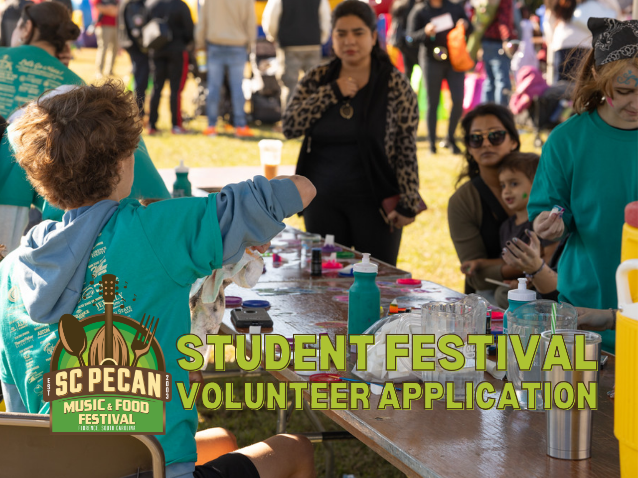 student volunteer assists with face painting at the pecan festival